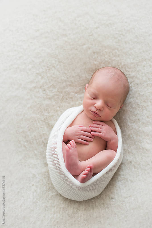 Beautiful newborn baby wrapped and sleeping on a blanket