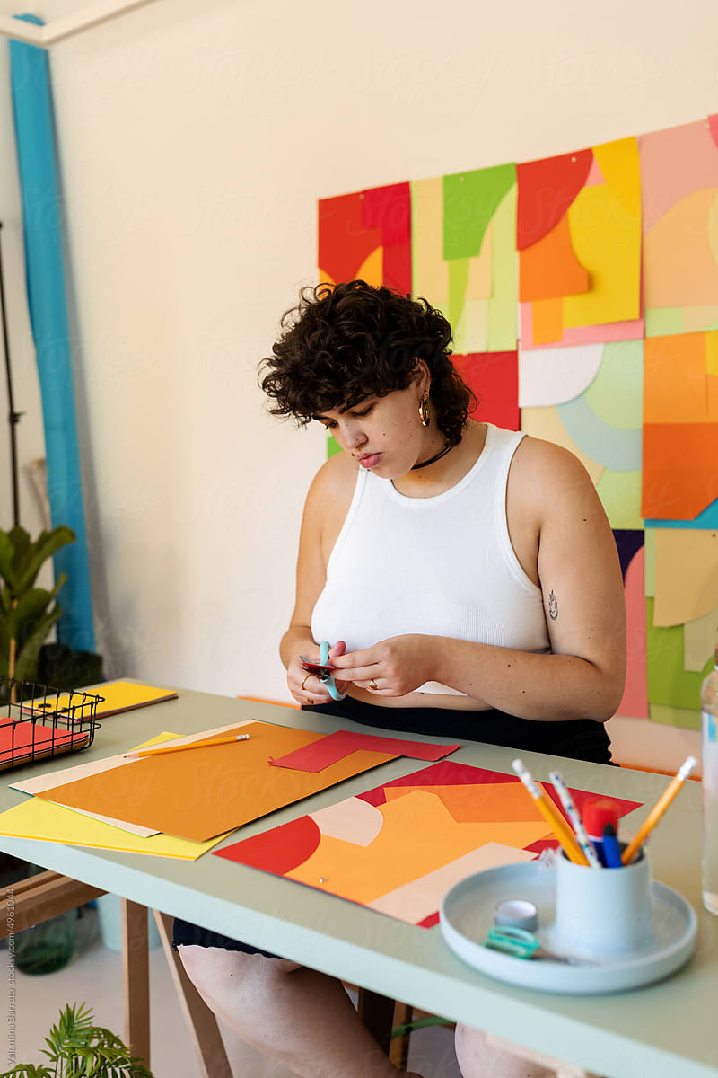 Woman making craft with colored papers in studio