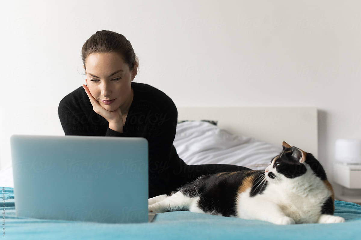 Woman looking at laptop on bed