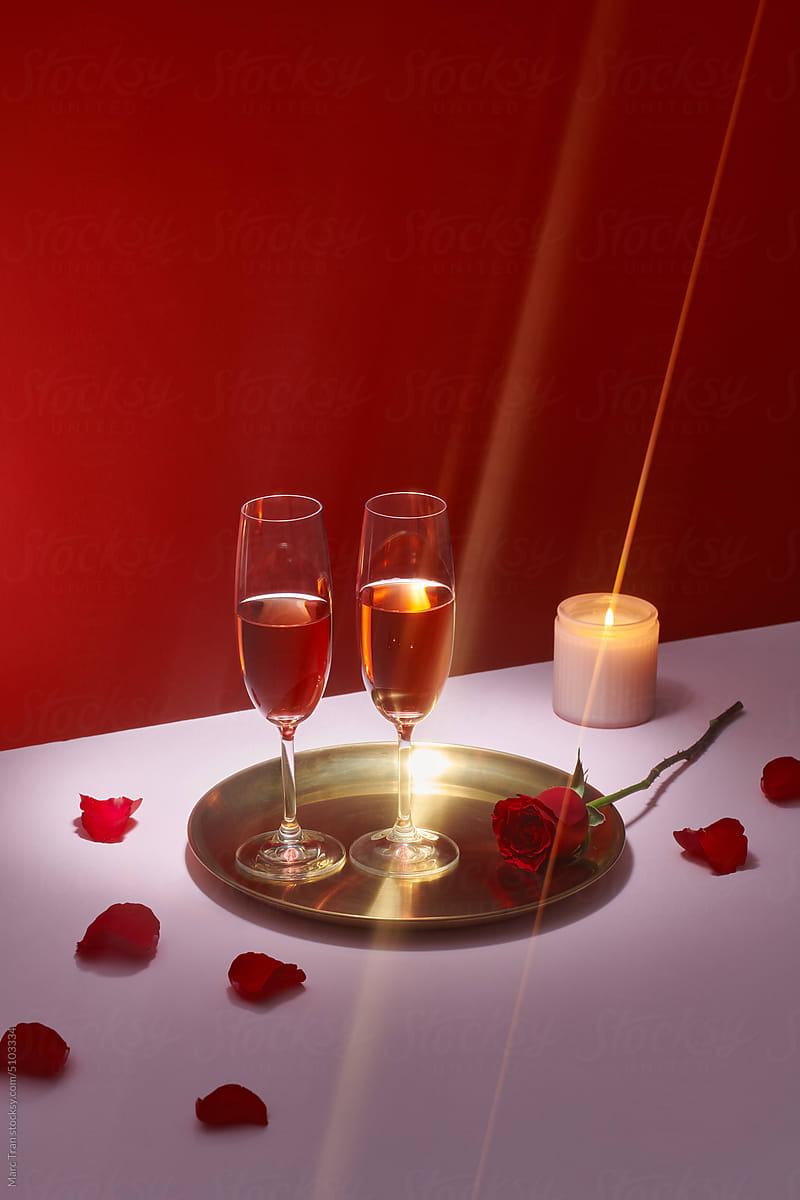 Champagne or wine in elegant glasses on a pink background