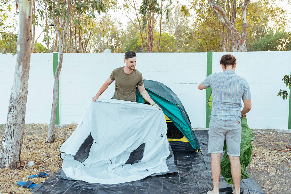 Group of friends putting the camping tent together