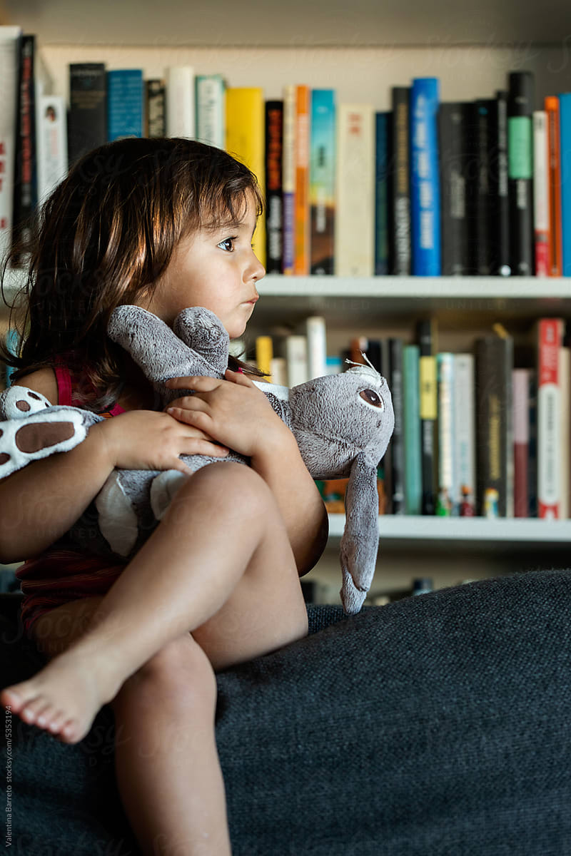 Adorable little girl with stuffed rabbit at home