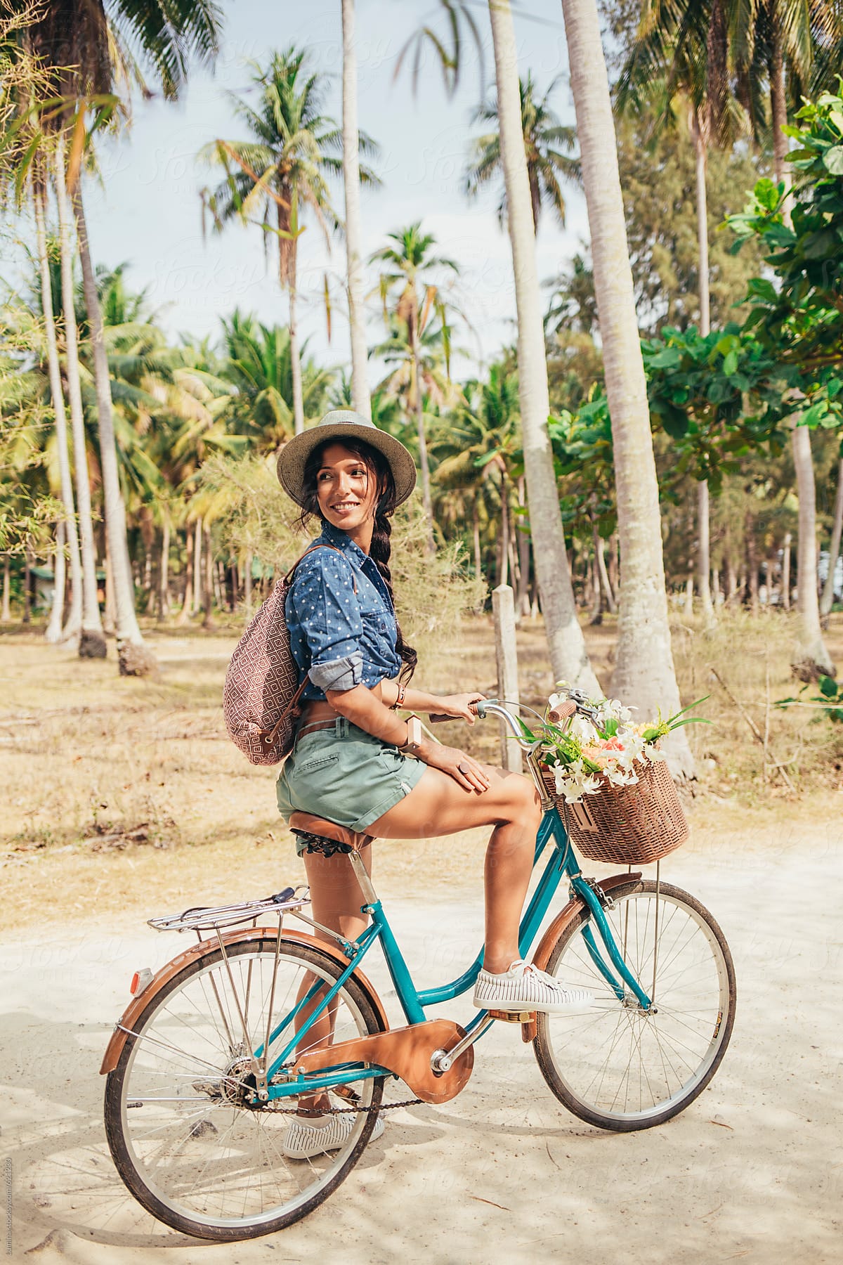 Happy Woman Riding a Bicycle in a Tropical Setting