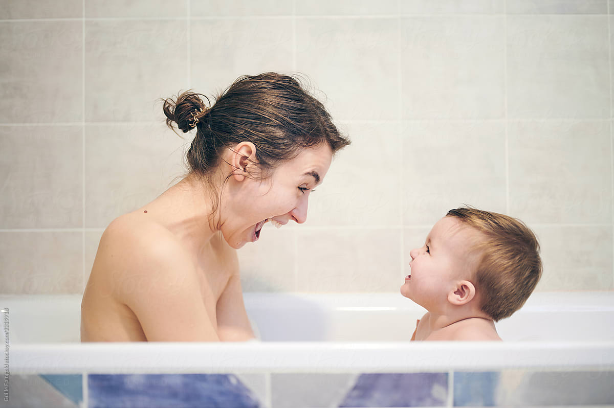 Laughing mother and baby in bath