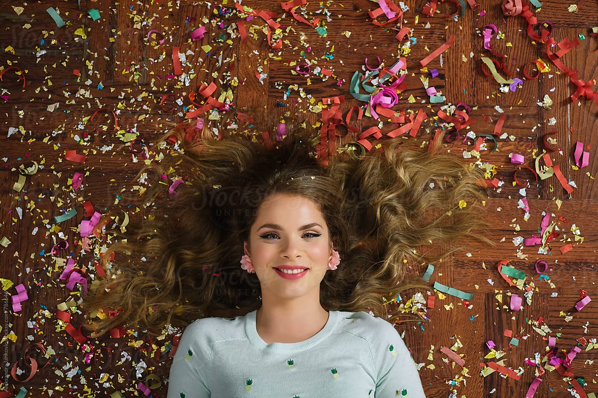 Overhead View Of A Beautiful Smiling Woman Lying On The Floor Covered