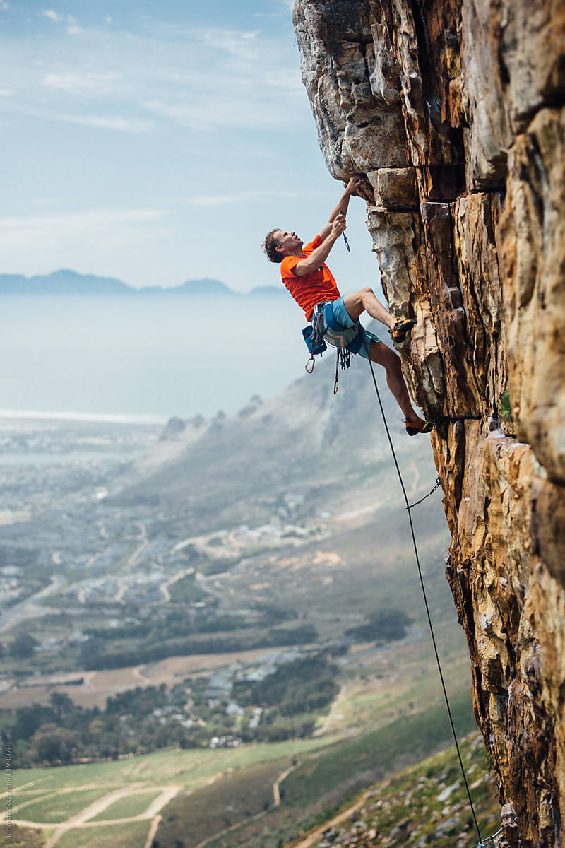 mountain climber climbing a mountain cliff - Stock Image - Everypixel