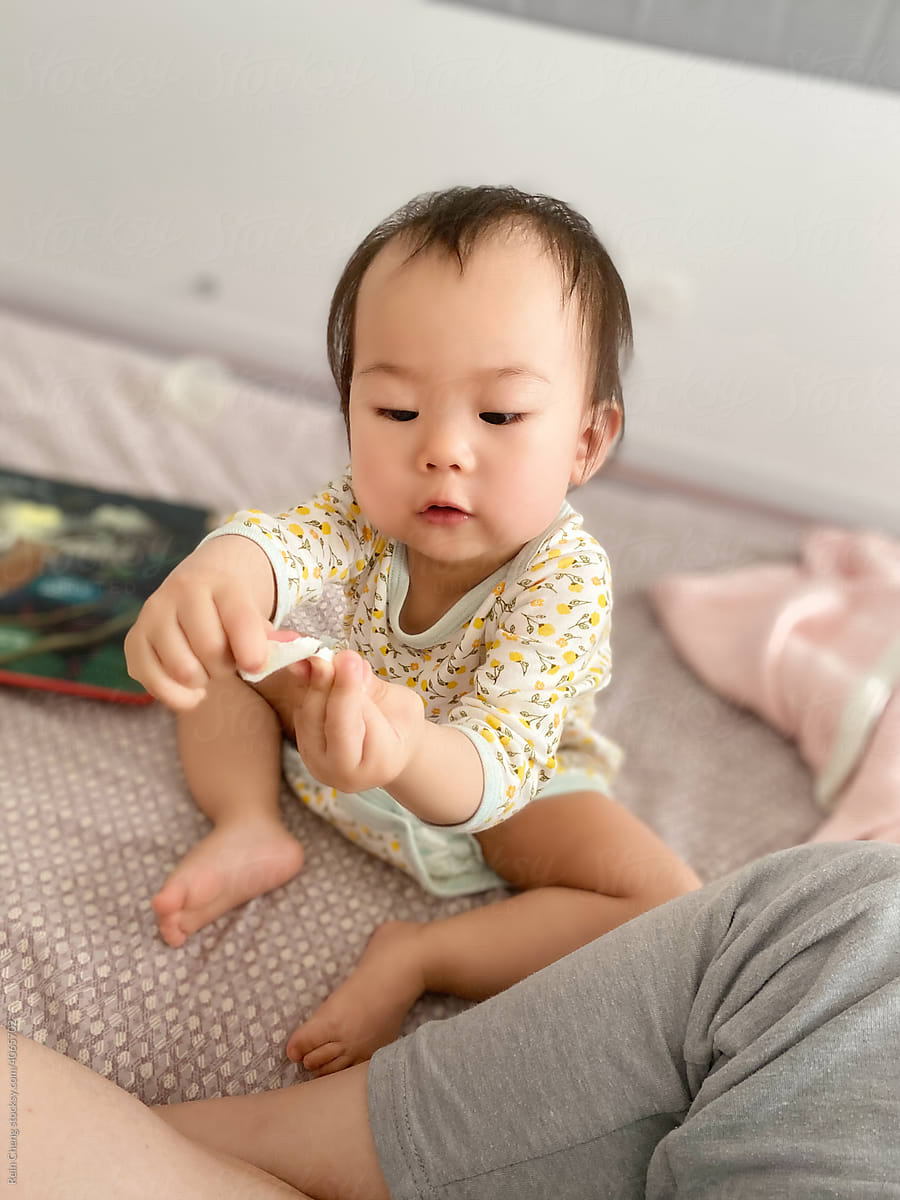 Asian baby tearing paper