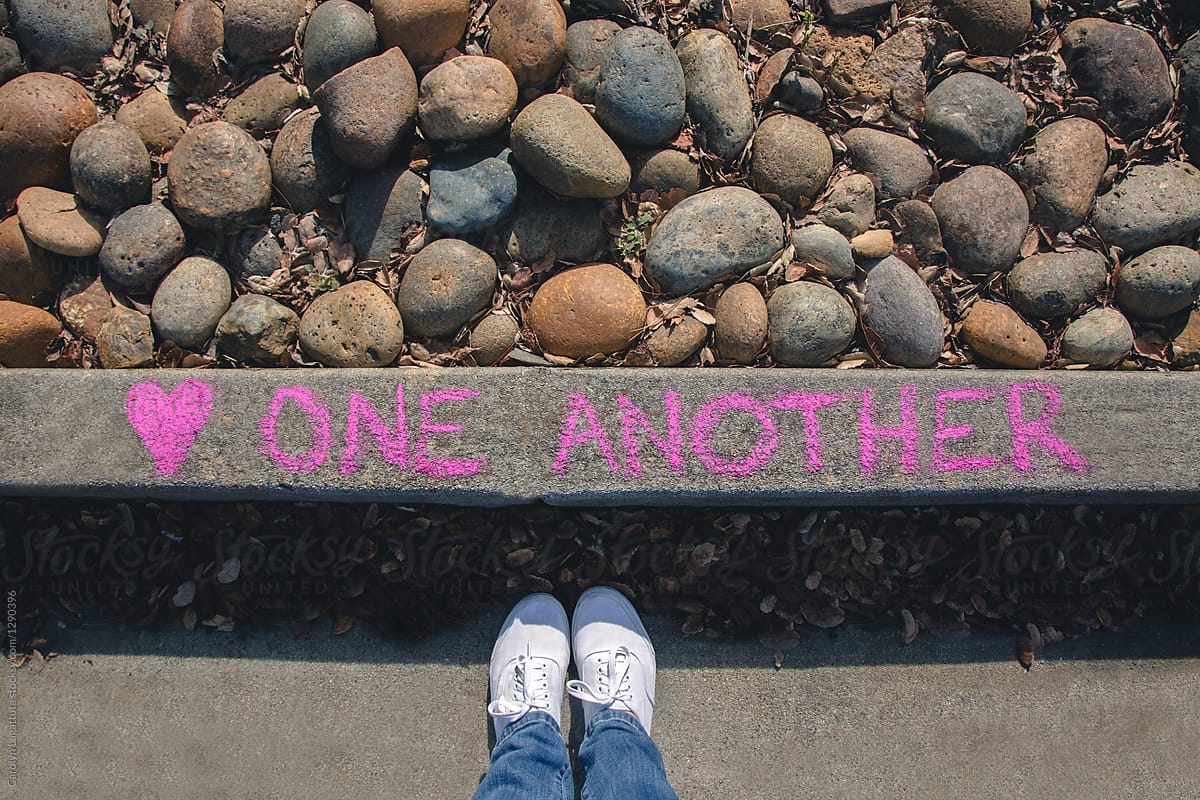 Message written on the curb saying Love one Another