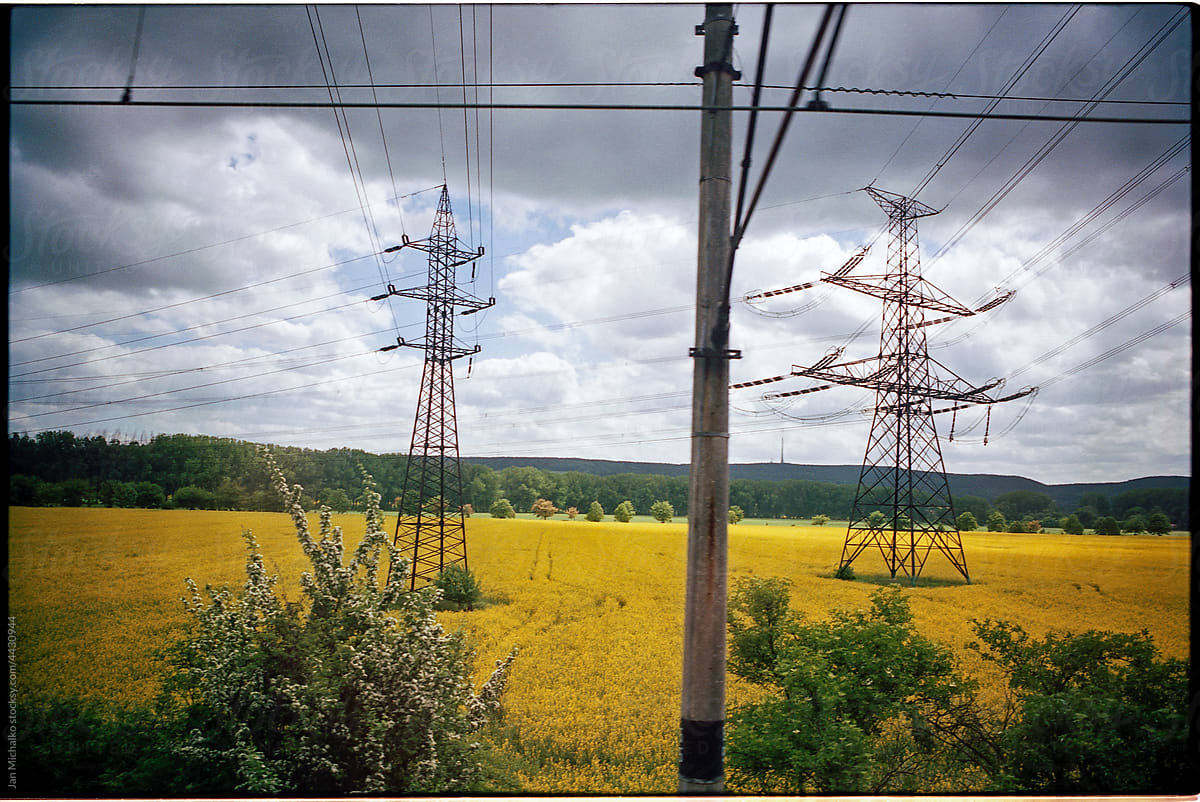 Landscape with a yellow field and electricity pylons
