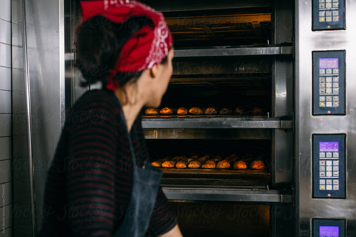 Baker checking bread in oven
