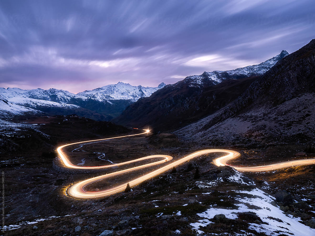 Light trails on swiss alps mountain pass road.