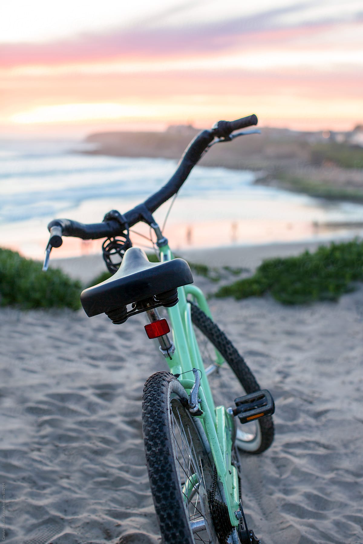 Mint green cruiser bike parked at the beach at sunset