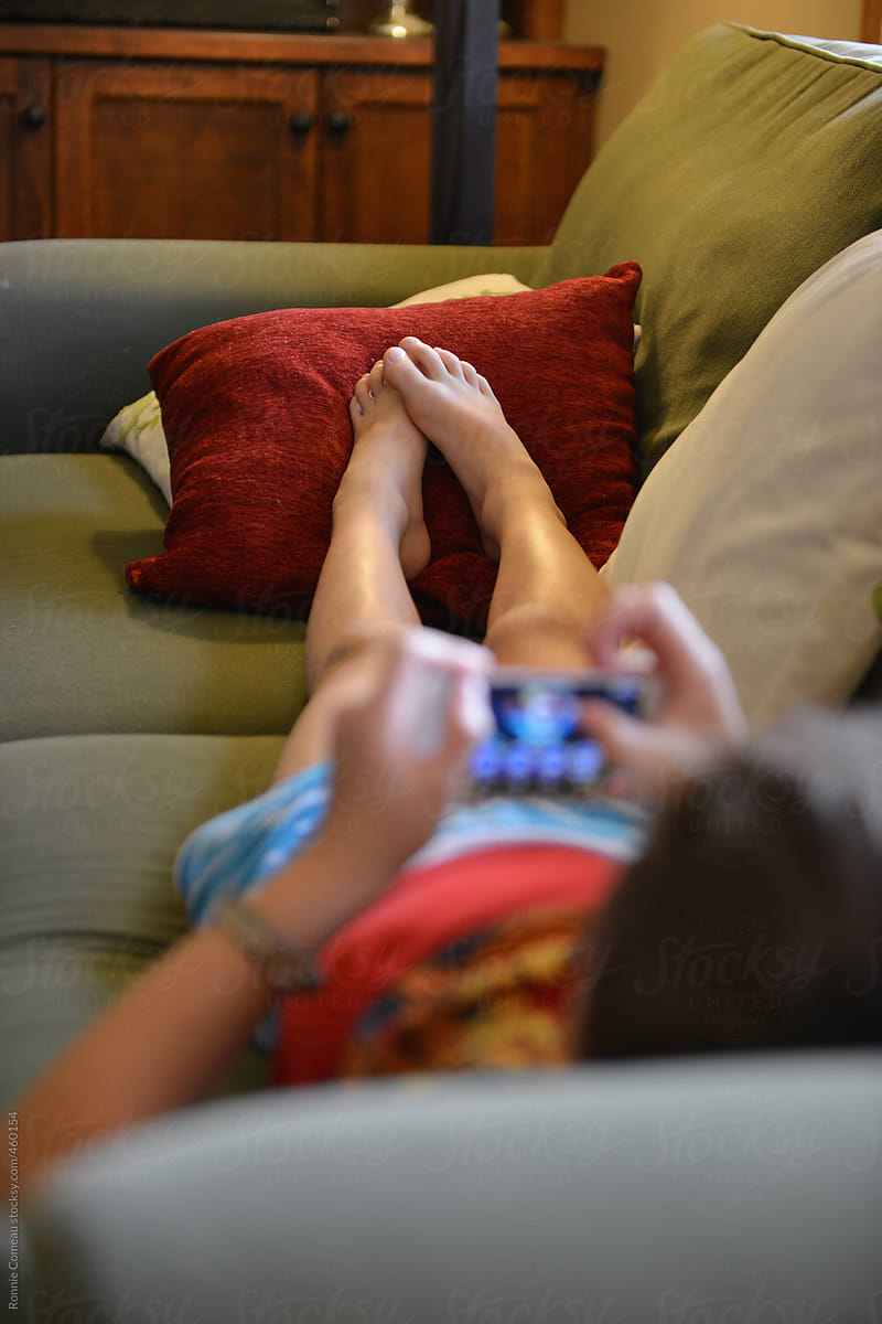 Boy Relaxing On Couch With Video Game