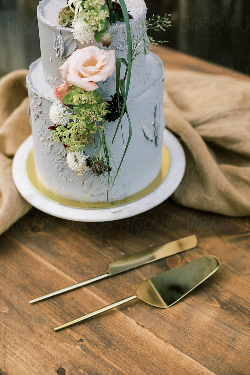 detailed view of a wedding cake and golden cutlery on a table