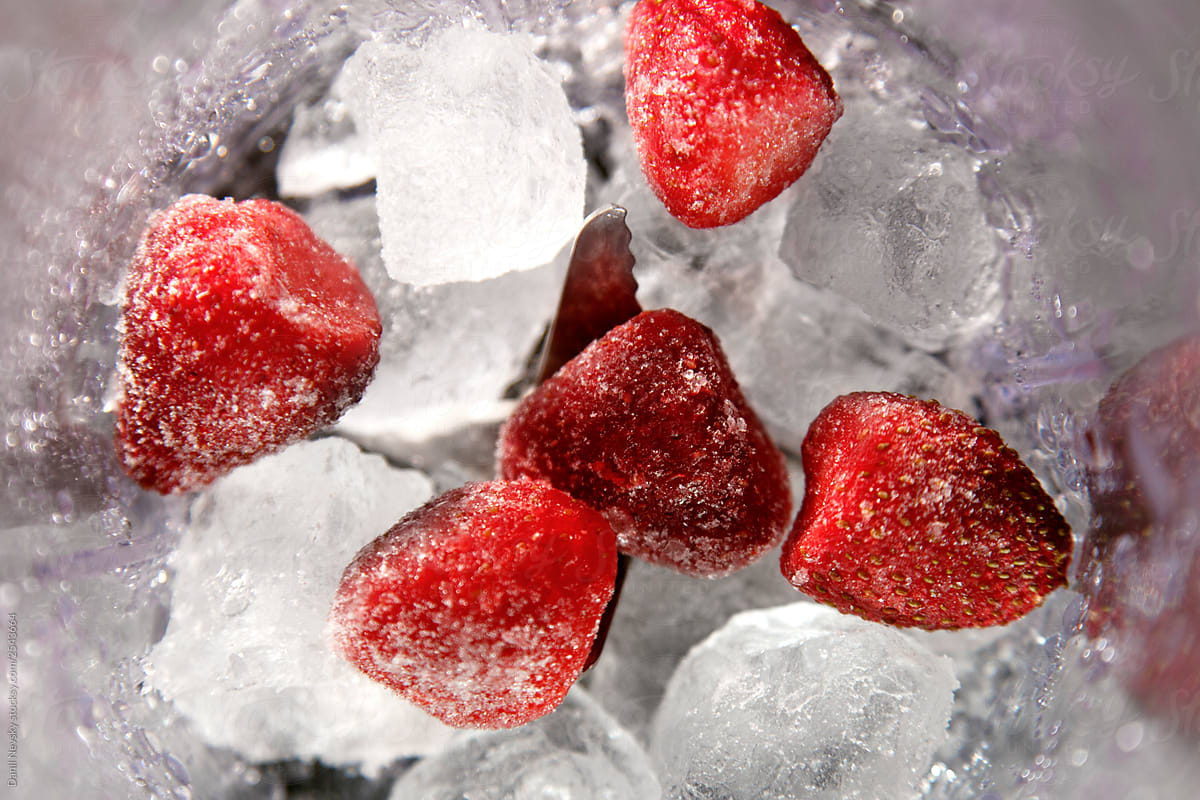 Ice with strawberries in a blender close-up