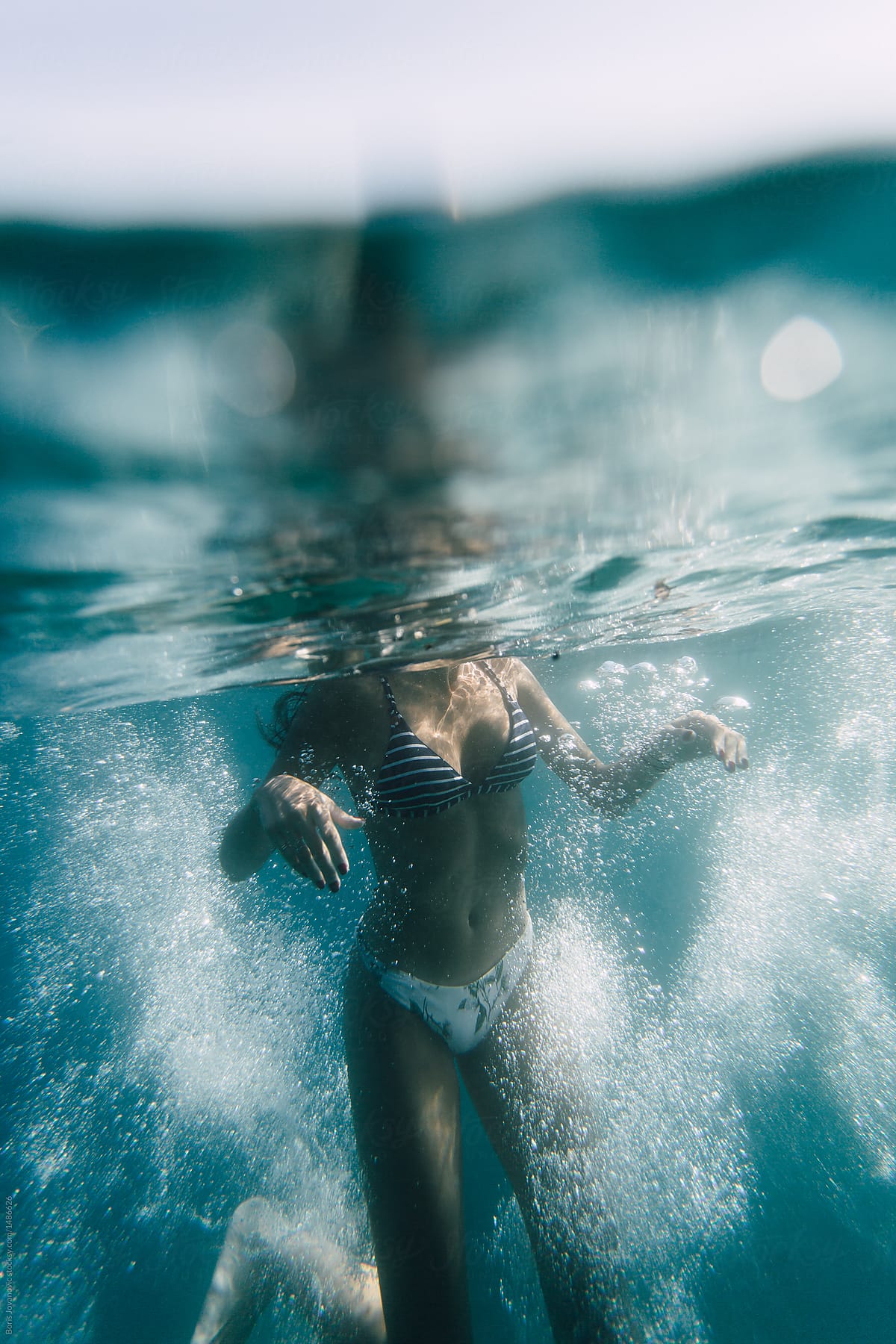 Crop Woman Wetting Legs In Sea Water by Stocksy Contributor BONNINSTUDIO   - Stocksy