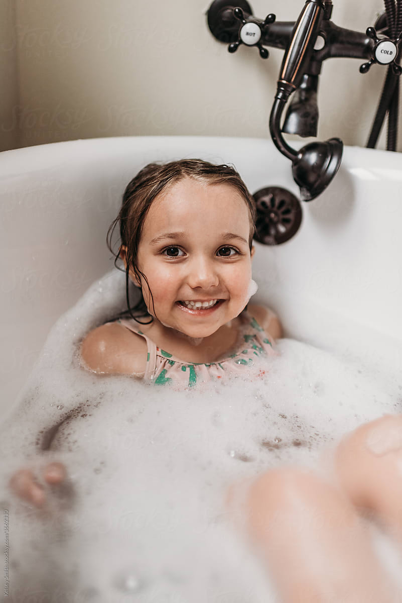 Adorable girl smiling in tub