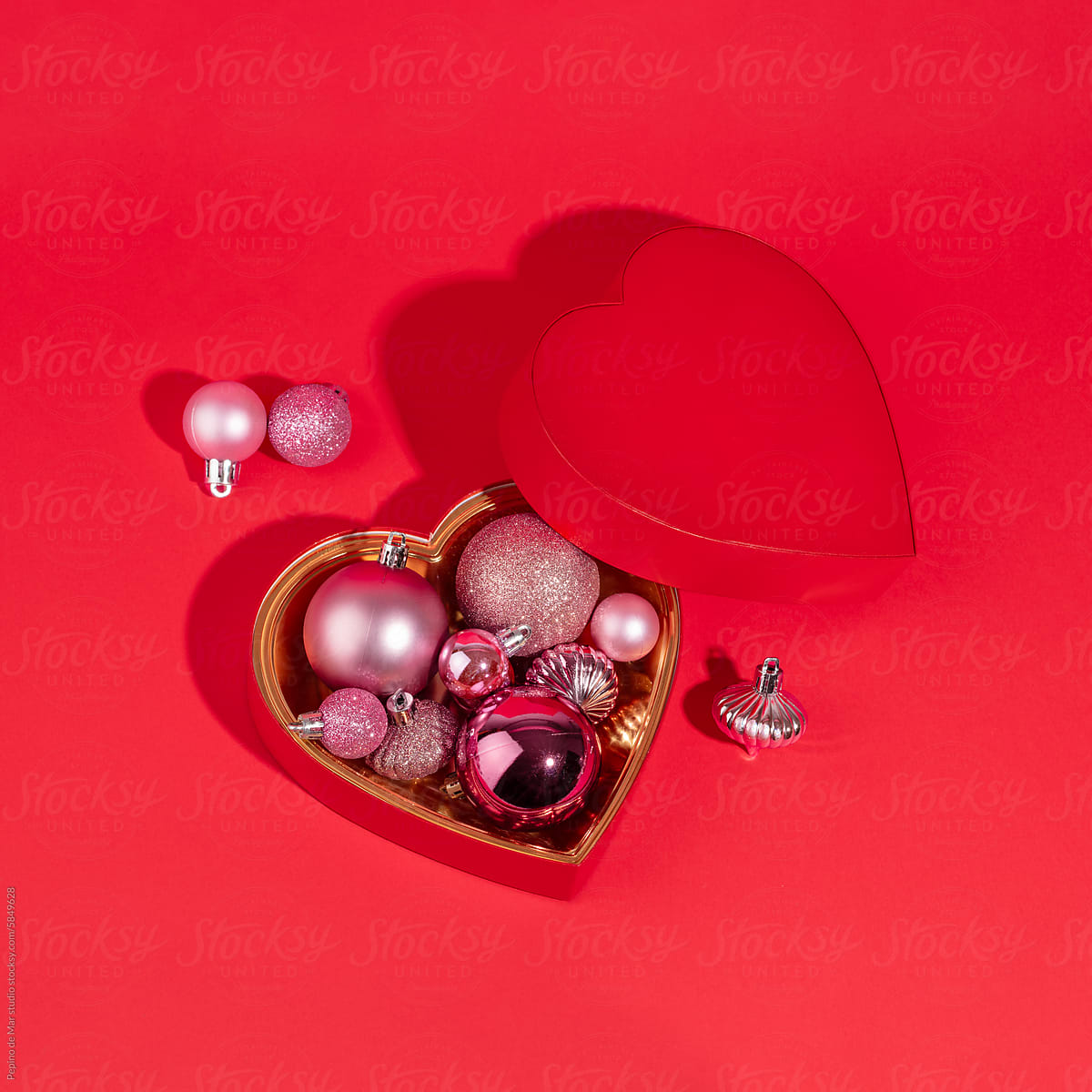 Heart-Shaped Box Filled with Pink Christmas Ornaments on Red
