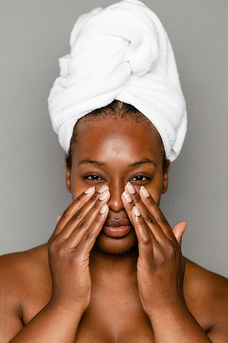 Black Woman Using Hands To Apply Skincare Products