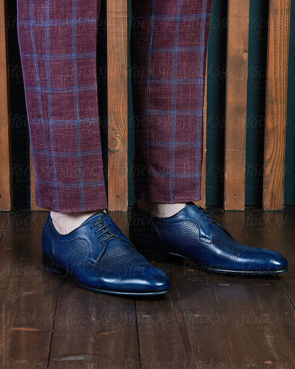 Male feet in blue classic leather shoes.