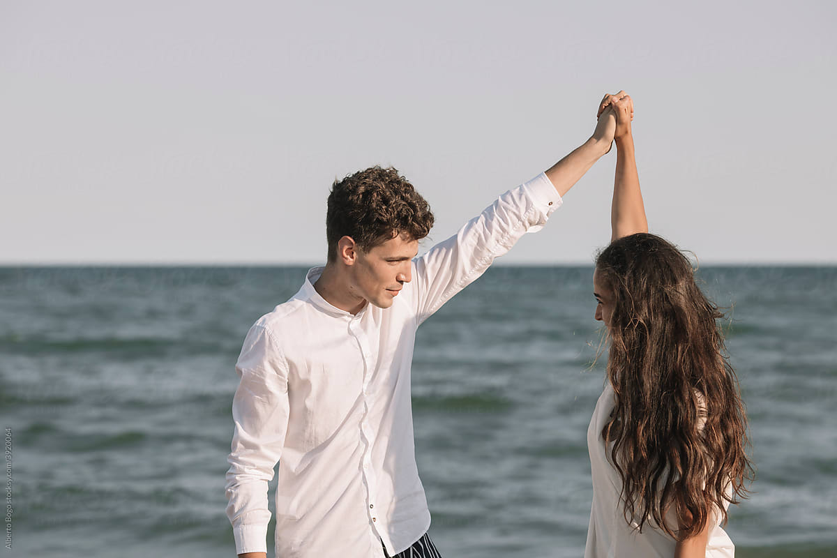 Young Couple In Love Walking On Te Shoreline