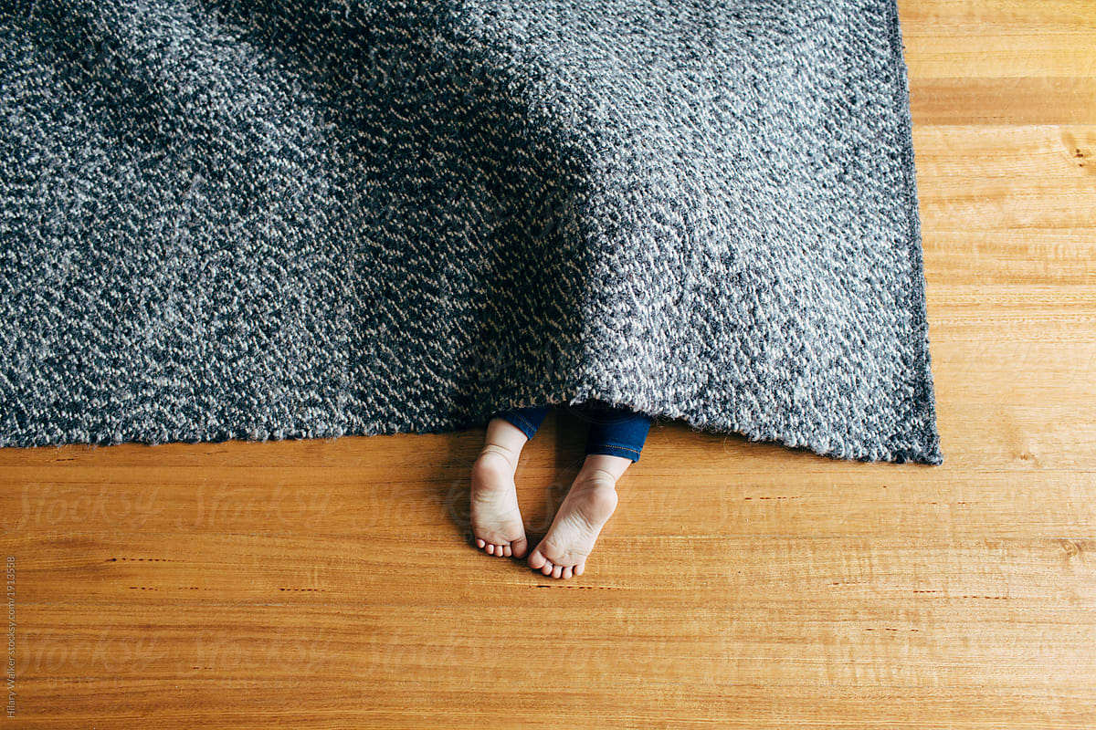 Child Hiding Under Rug by Stocksy Contributor Hilary Walker - Stocksy
