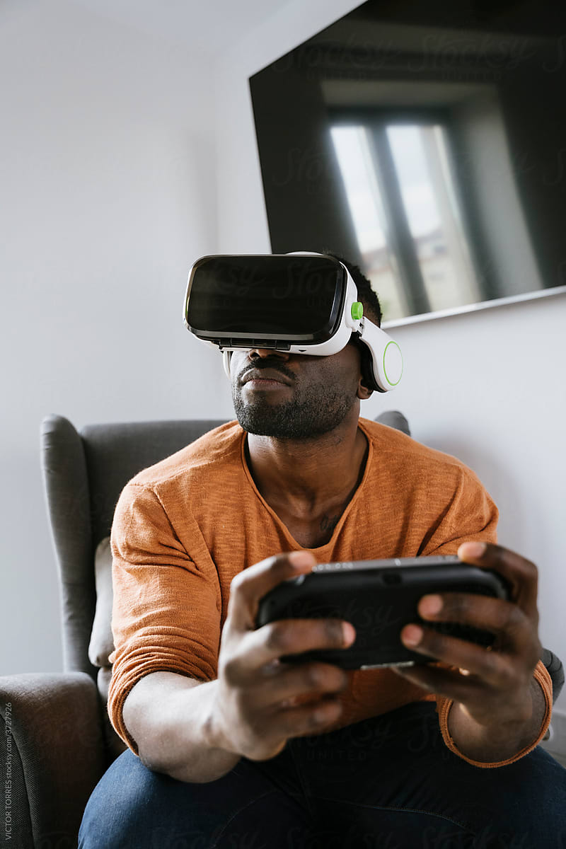 Cheerful black man experiencing virtual reality in VR glasses