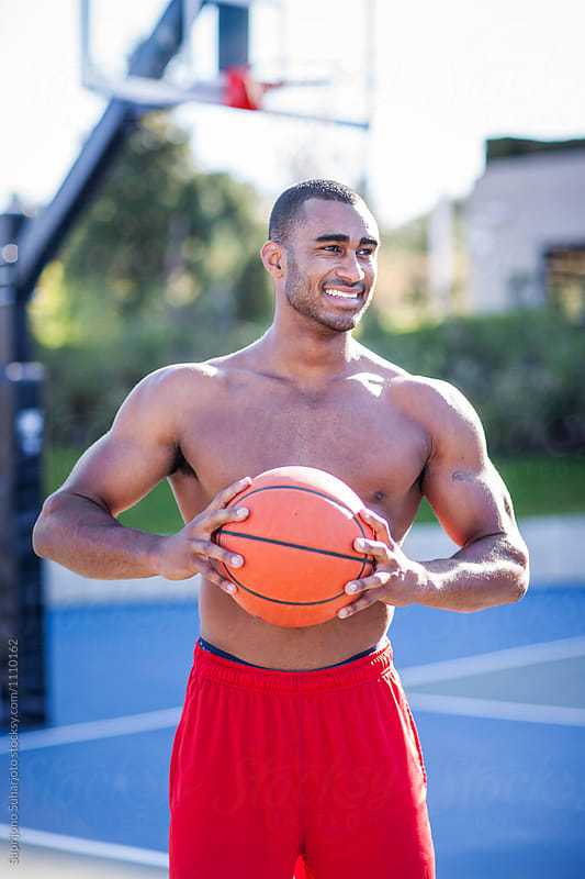 African American man playing basketball on an outdoor court