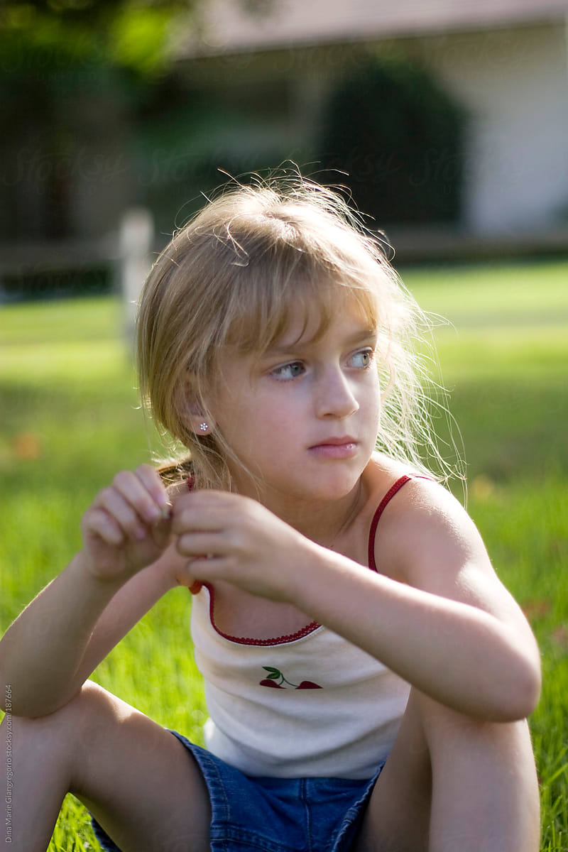 Young Blonde Girl Sitting On Grass Thinking By Stocksy Contributor Dina Marie Giangregorio