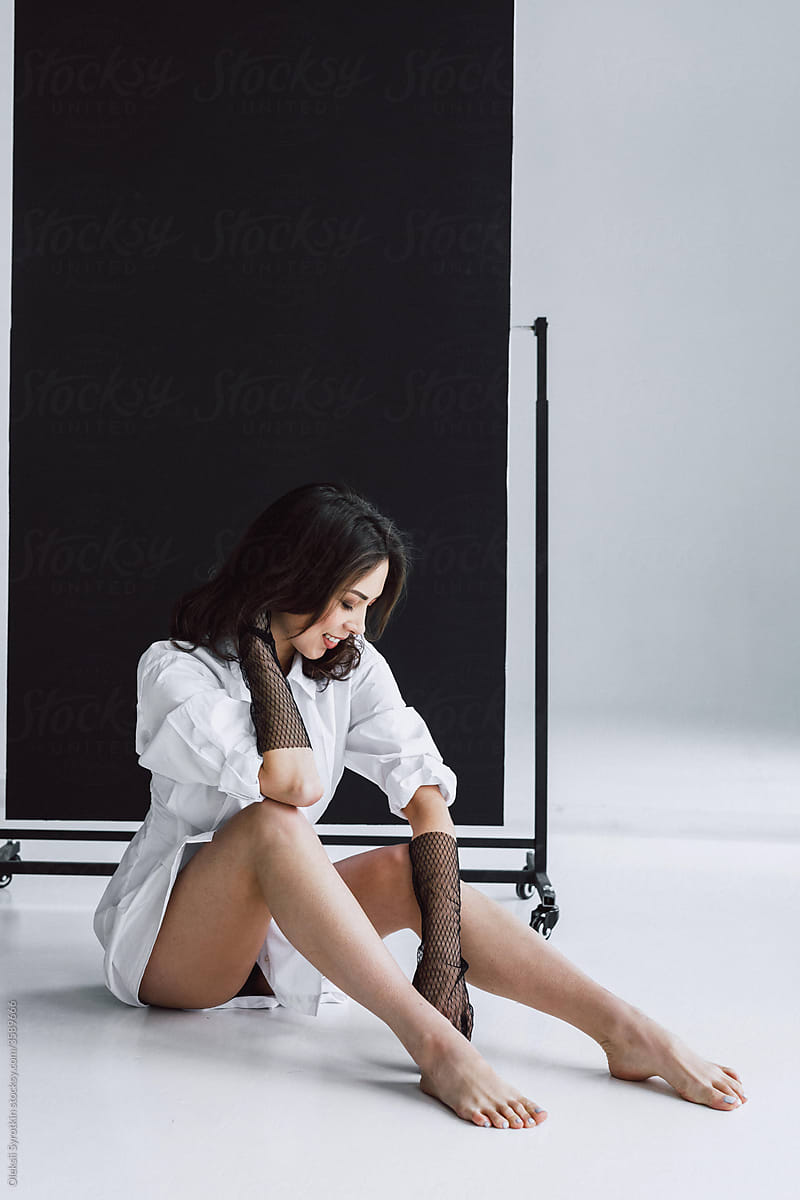 Woman in white blouse posing in studio