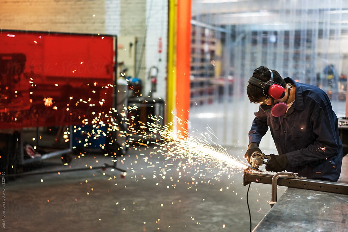 Young man creating sparks in a factory
