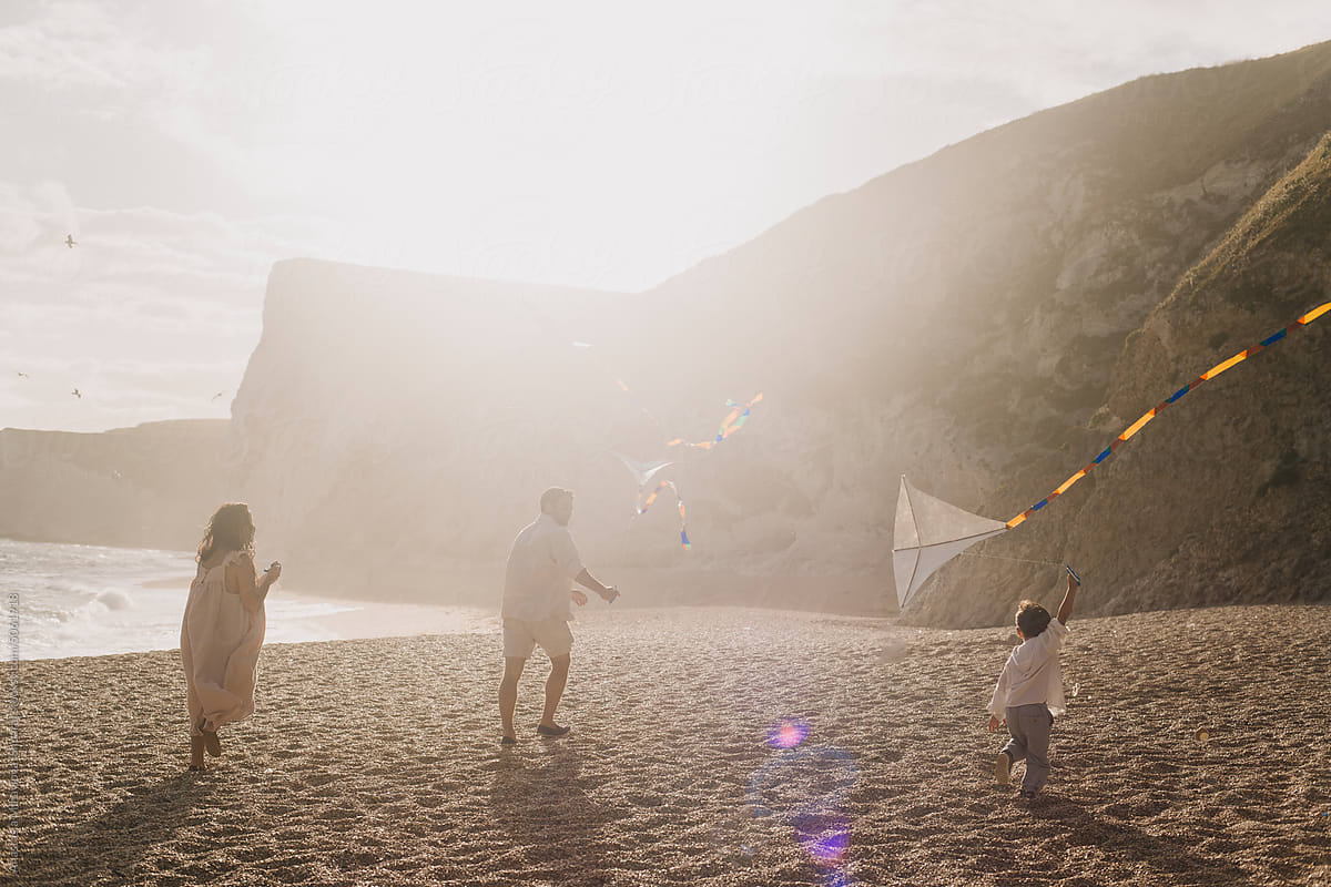 Happy Family Playing With A Kite, Having  Fun together Near Ocean