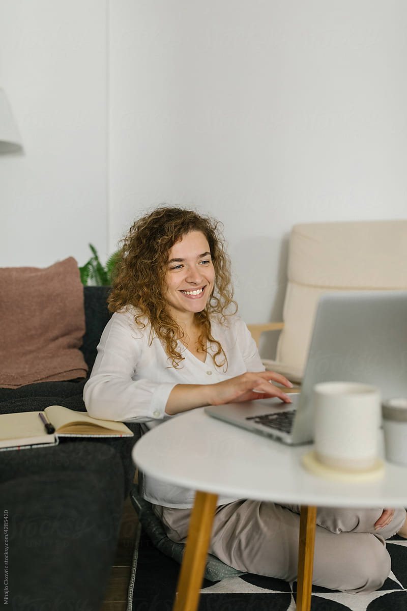 Smiling woman using computer at home