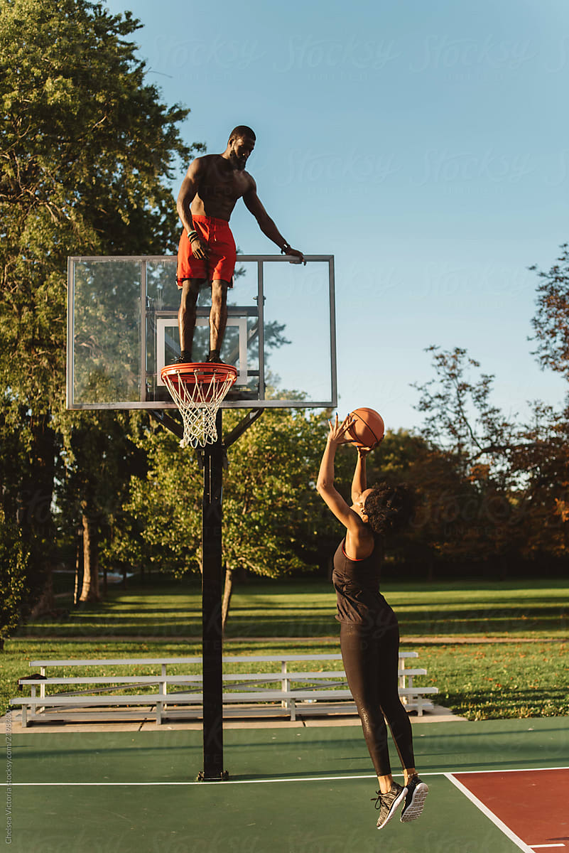 An Attractive African American Couple playing basketball on a sunny day
