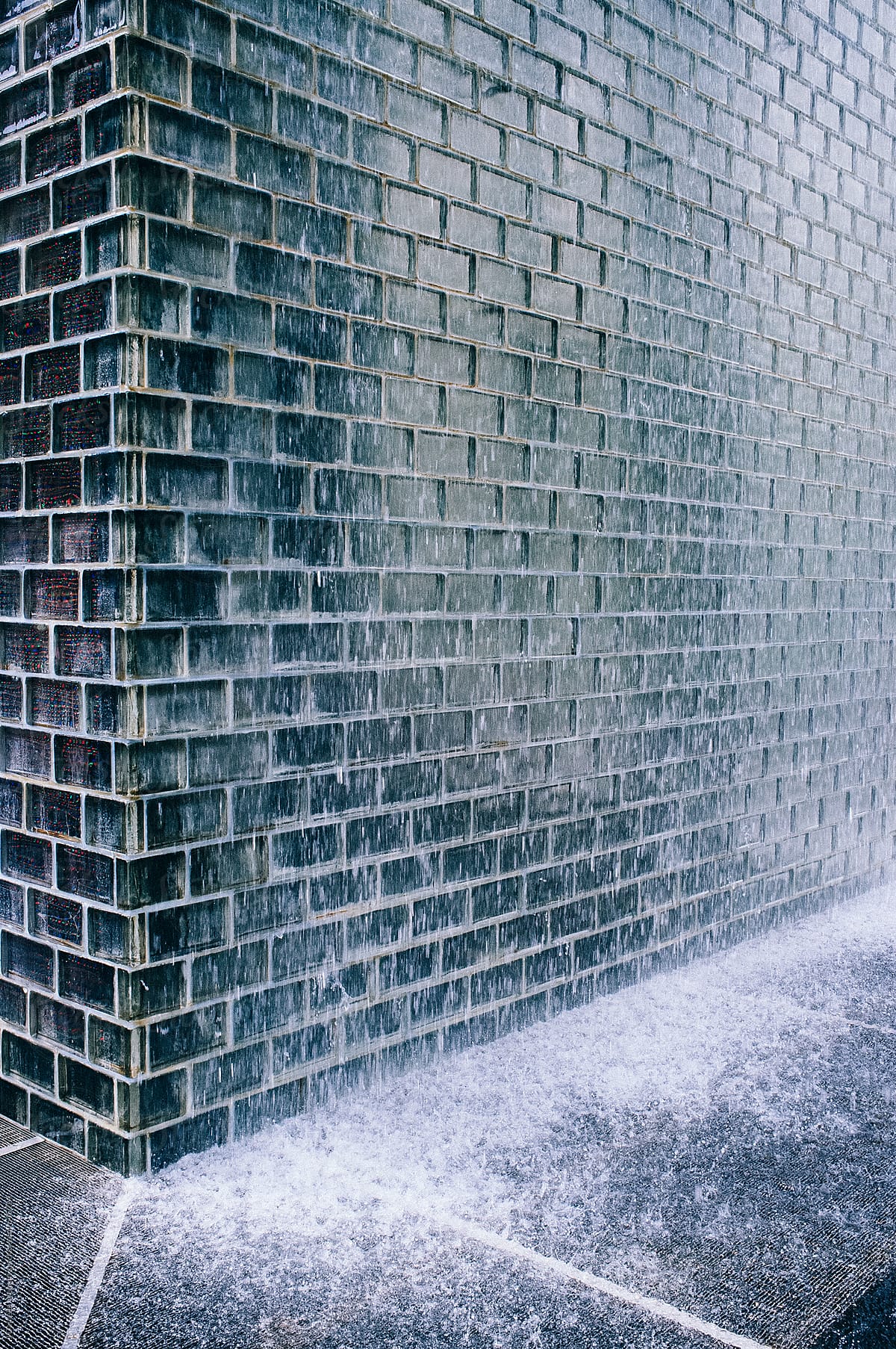 Water falling in front of black brick water fountain.