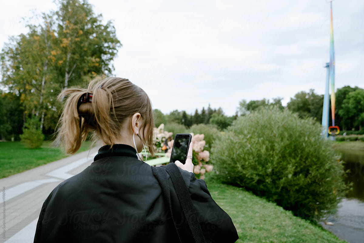 Back view of a girl searching on mobile phone