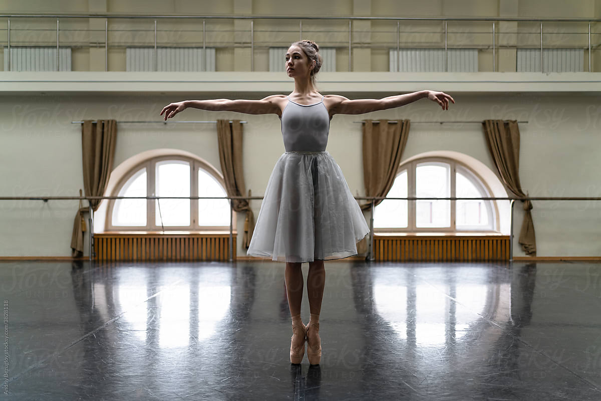 Female ballet dancer posing inside dance hall