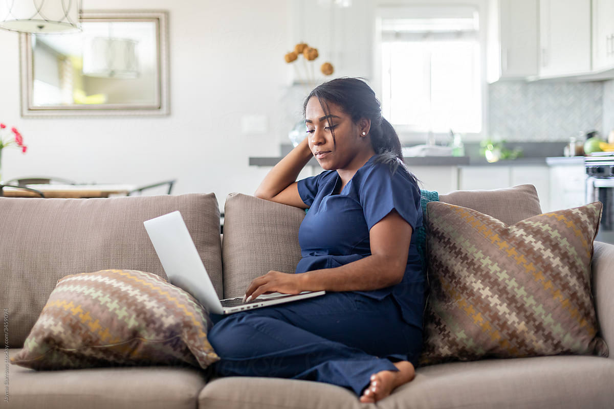 Woman Focuses On Her Computer On The Couch By Stocksy Contributor Jayme Burrows Stocksy 