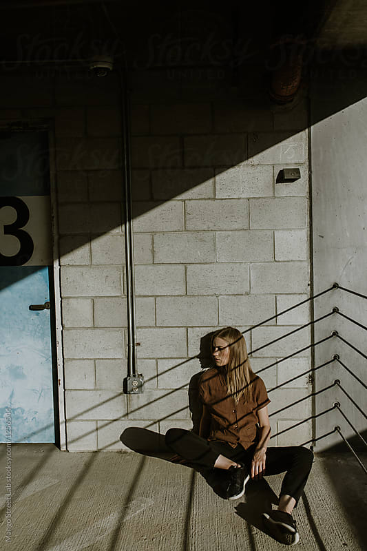Woman Model Sitting Outdoors with Shadows and Harsh Light on Her Face