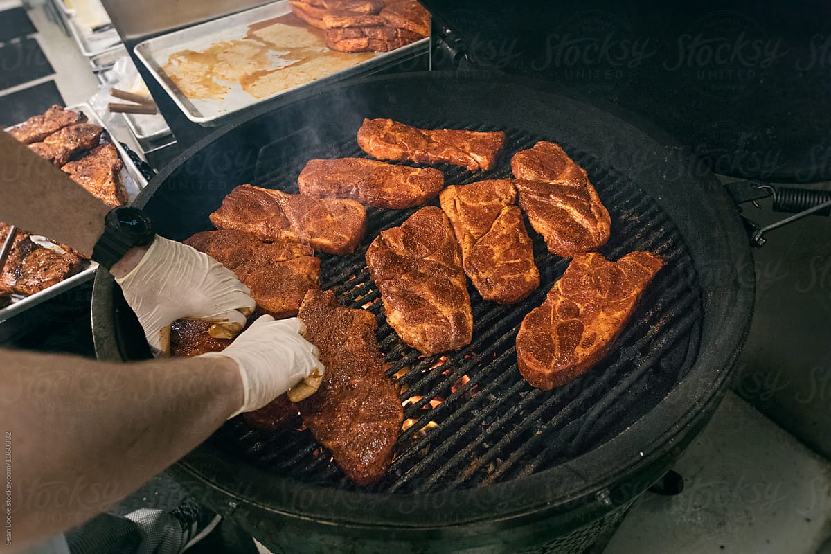 Kitchen: Cook Puts Dry Rubbed Steaks Onto Grill