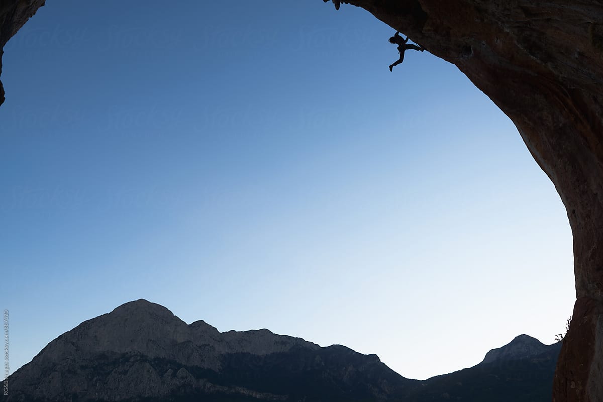 Climber silhouette climbing a overhanging wall