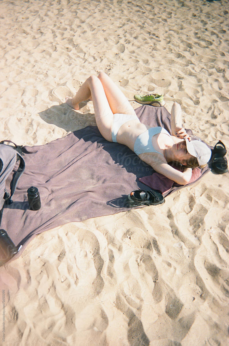 Woman lying on sandy beach