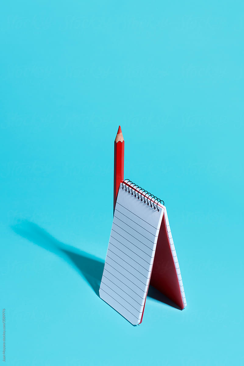 red pencil and spiral notepad