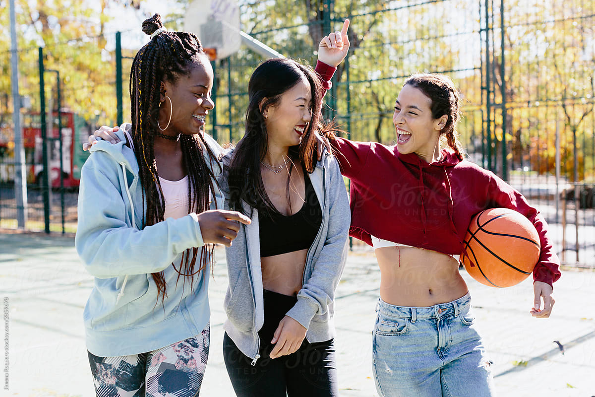Multi ethnic group of friends with basketball ball hanging out