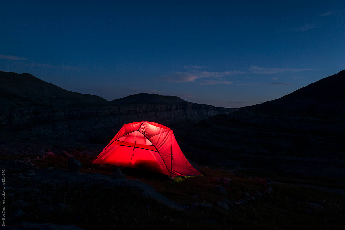 Illuminated red tent during the night on mountains