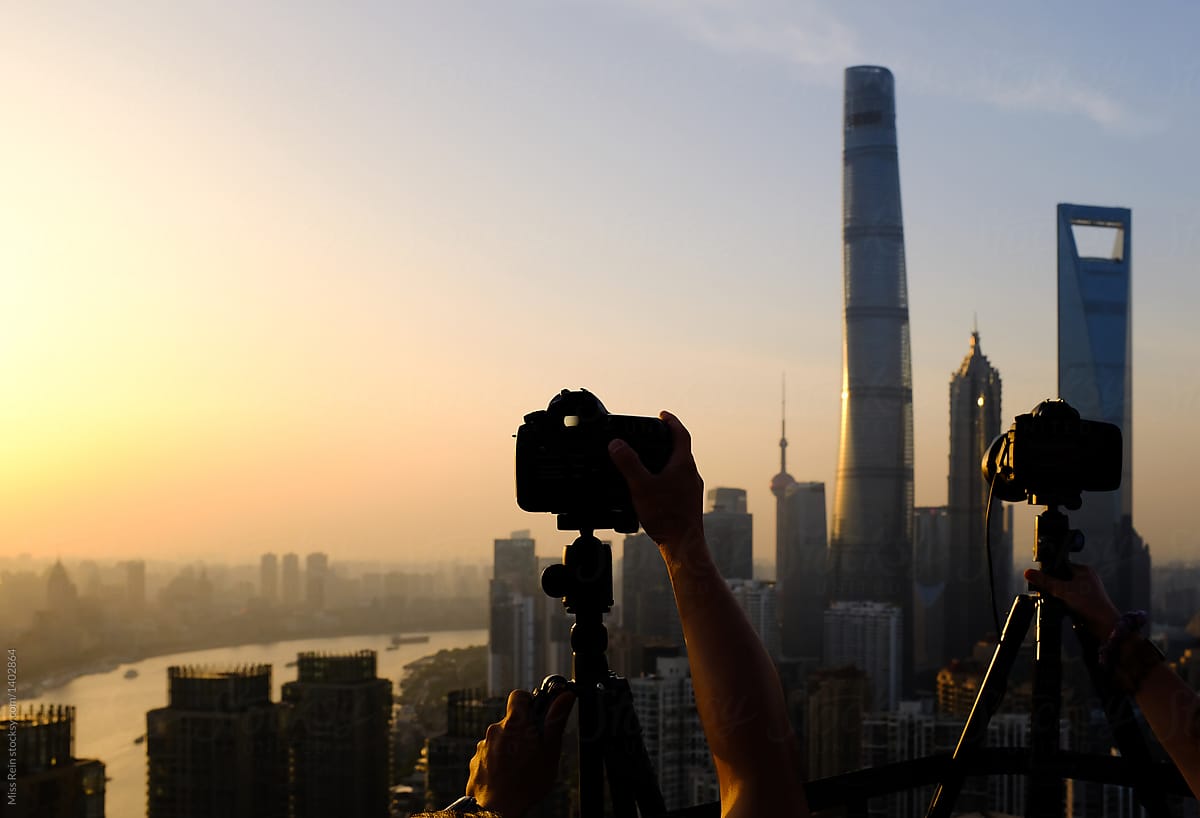Silhouette camera shoots the city sky at sunset
