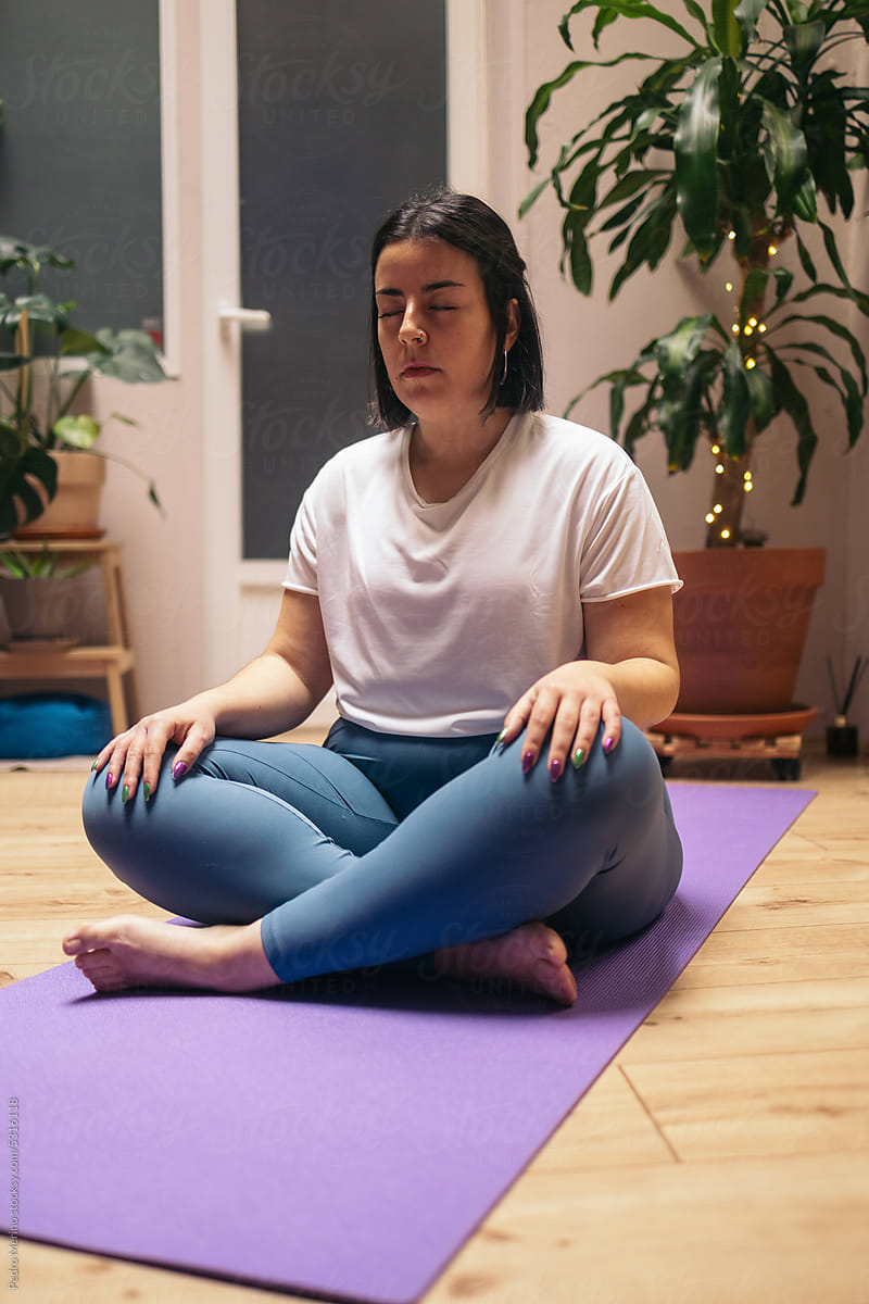 Close-up of a woman doing yoga in a cozy room