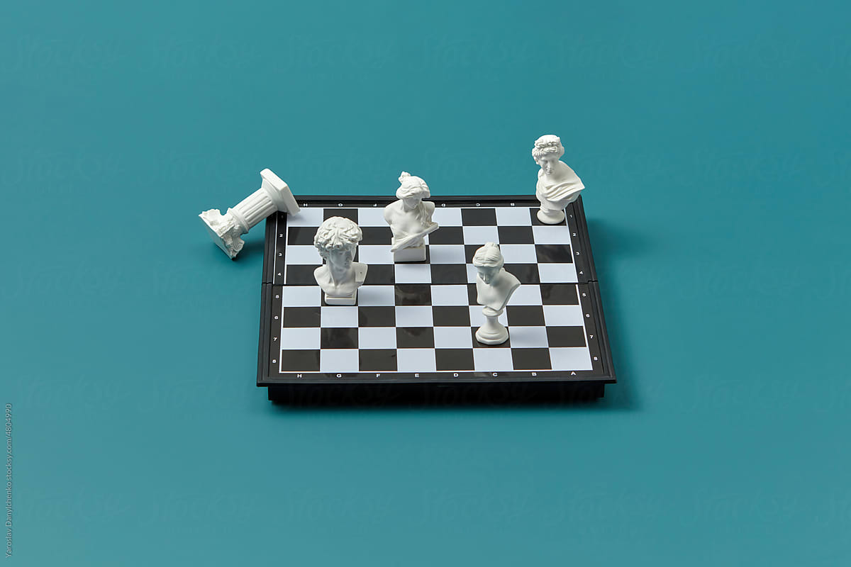 White plaster statues arranged on chessboard.