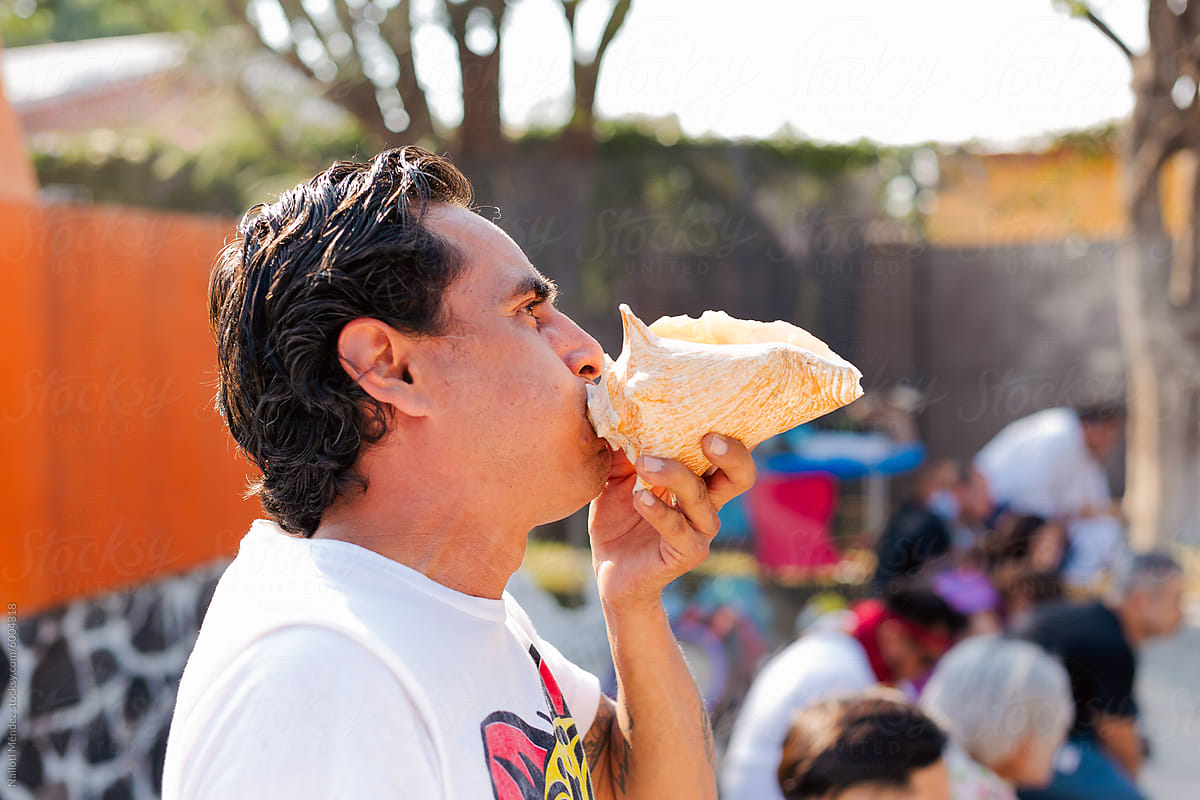 Man playing the conch in ceremony