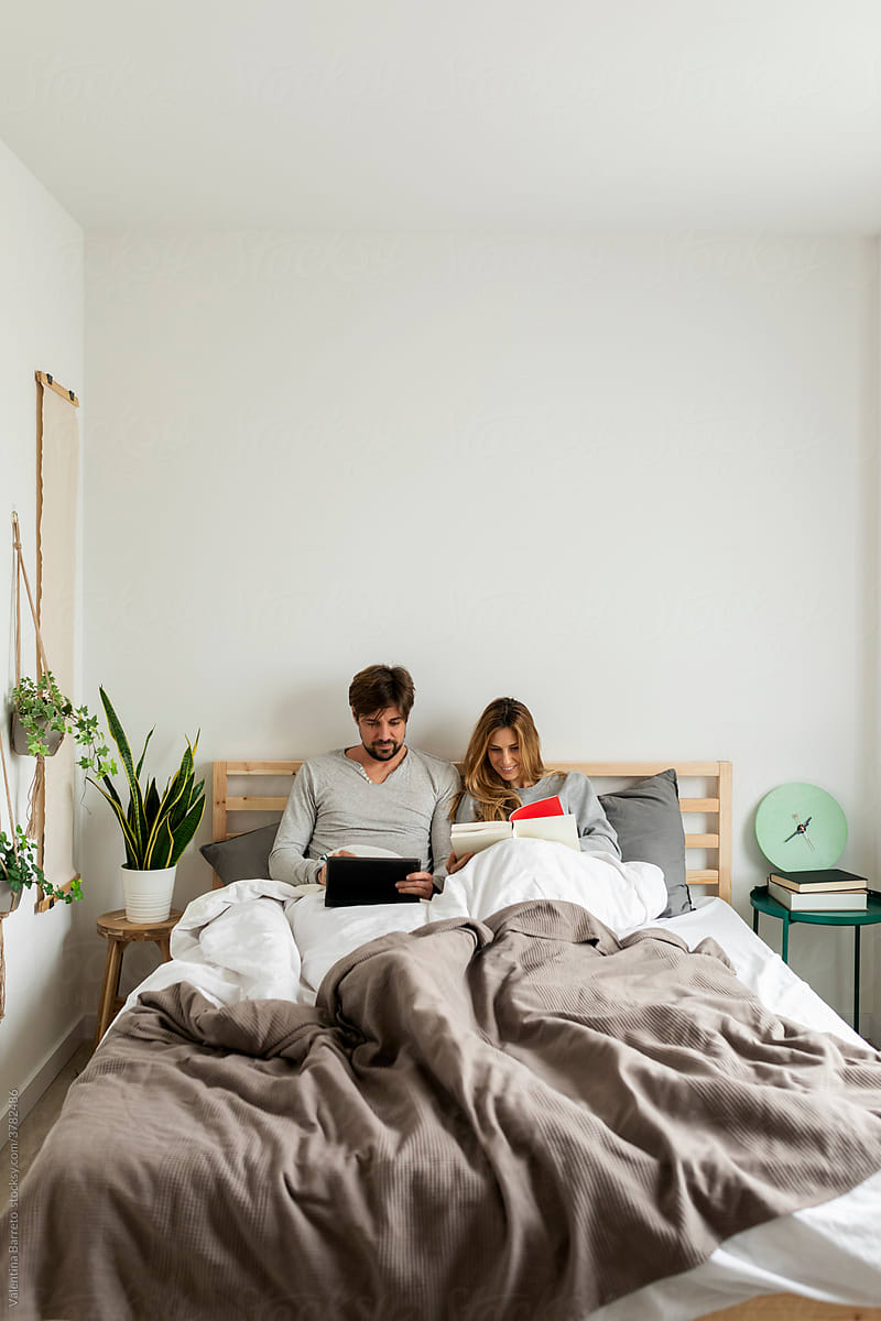 Couple In Bed Using Laptop For Wifi Entertainment